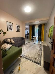 a living room with a couch and a rug at Cozy 1-Bed Apt with Pool & Gym in Najjera 2 in Kira
