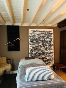 a bedroom with a bed with a picture on the wall at Maison Galerie Art n Pepper in Solwaster