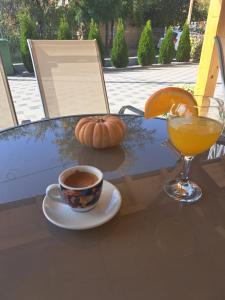 a table with a cup of coffee and a pumpkin and a drink at Villa Ristovski in Ohrid