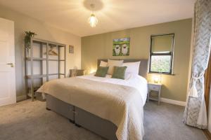 a bedroom with a large bed and a window at Oak Lodge House in Leyburn