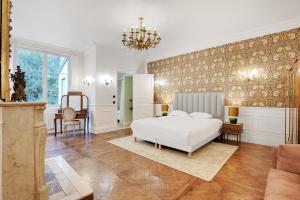 a bedroom with a white bed and a couch at CMG Jardin du Luxembourg - Pantheon in Paris