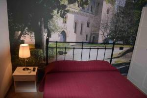 a bedroom with a bed and a window with a building at Hotel Il boschetto in Tolentino