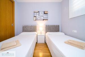 deux lits dans une petite pièce aux murs blancs dans l'établissement Luxury 2 Bed 2 Bath Apartment with pool, à El Campello 24 autres photos