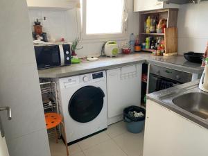 eine Küche mit einer Waschmaschine und einem Waschbecken in der Unterkunft Une chambre single avec accès direct Aéroport d'Orly T4 in Orly
