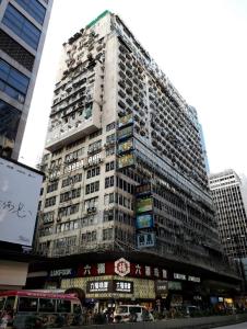 香港にあるBlue Sky Hotelの時計が前に建つ高層ビル