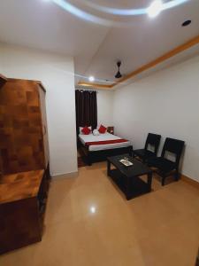 a bedroom with a bed and a table and chairs at Hotel Knight Inn Airport in Guwahati