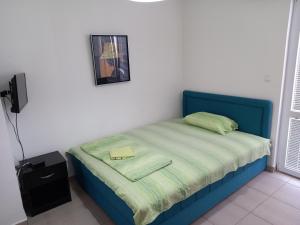 een klein bed in een slaapkamer met een blauw bedframe bij Apartments Pure Magic in Utjeha