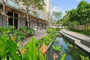 einen Garten mit einem Teich vor einem Gebäude in der Unterkunft Cielo by Kozystay - 2BR - Spacious - Kuningan in Jakarta
