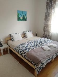 sypialnia z łóżkiem z niebiesko-białym kocem w obiekcie Zsuzsanna Vendégház w mieście Gyomaendrőd