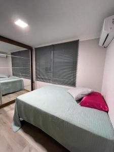 a bedroom with a large bed in a room with windows at Apto duplex Lagoa do Violão in Torres