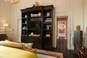 a black entertainment center with a television in a living room at Rocco Forte Villa Igiea in Palermo