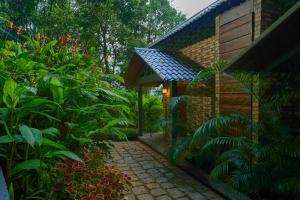 a garden with a small building and a pathway at Elephant Passage in Munnar