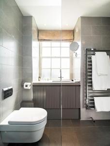 a bathroom with a toilet and a shower and a window at AKA Marylebone in London +37 photos
