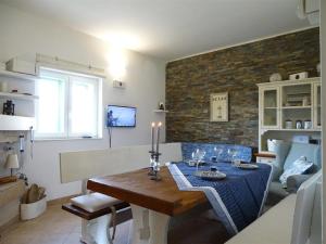 een woonkamer met een eettafel en een woonkamer met een bakstenen muur bij Vransko Lake House in Pirovac
