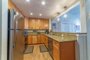 a kitchen with wooden cabinets and a stainless steel refrigerator at #572 Walk to Eagle Lodge with Spa & Pool in Mammoth Lakes
