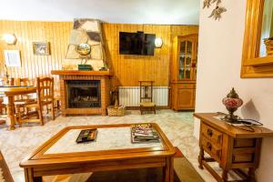 a living room with a table and a fireplace at La Casa de Quico in Nocedo de Curueño