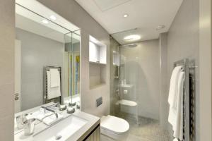bagno con lavandino, servizi igienici e specchio di AKA Marylebone a Londra