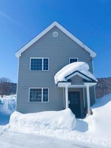 a house covered in snow with snow around it at Niseko Powder fox in Niseko