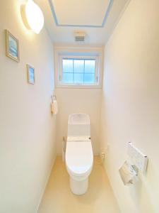 a bathroom with a toilet with a window at Niseko Powder fox in Niseko