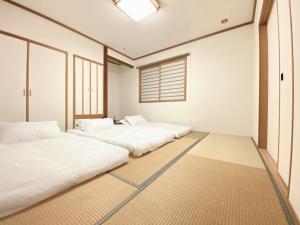 three beds in a room with a window at Niseko Powder fox in Kutchan