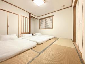 three beds in a room with a window at Niseko Powder fox in Niseko