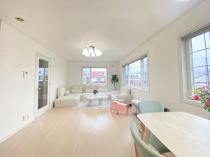 a large white living room with a table and chairs at Niseko Powder fox in Niseko