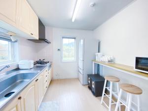 a kitchen with a sink and a refrigerator at Niseko Powder fox in Niseko +8 photos