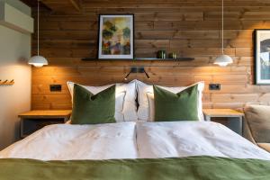 a bedroom with a white bed with green pillows at Gaustablikk Fjellresort in Gaustablikk