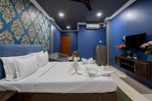 1 dormitorio con 1 cama grande y pared azul en Destino Hotel, Goa, en Candolim