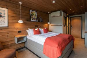 ein Schlafzimmer mit einem Bett in einem Zimmer mit Holzwänden in der Unterkunft Gaustablikk Fjellresort in Gaustablikk
