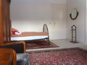 een slaapkamer met een bed, een tafel en een tapijt bij Privatzimmer Wagner in Hannover