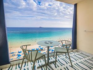 einen Balkon mit einem Tisch und Stühlen sowie Strandblick in der Unterkunft Barceló Benidorm Beach - Adults Recommended in Benidorm