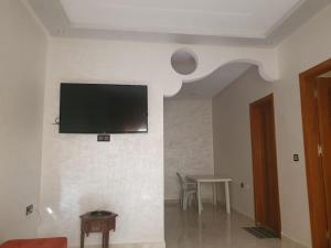 a living room with a tv on a wall at Apartment in Larache Marokko in Larache