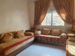 un soggiorno con un divano e una finestra di Apartment in Larache Marokko a Larache