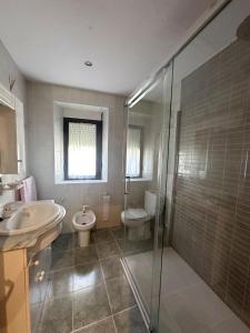 a bathroom with a sink and a toilet and a shower at La Casa de Quico in Nocedo de Curueño