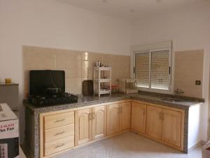 a kitchen with wooden cabinets and a counter top at Apartment in Larache Marokko in Larache