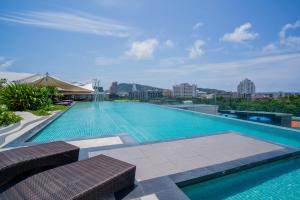 Mercure Phuket Patong Journeyhub في شاطيء باتونغ: حمام سباحة كبير أعلى مبنى