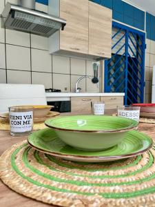 uma tigela verde num prato num balcão de cozinha em Blue Wave Apartment em Bari