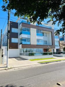 a large building on the side of a street at Apto duplex Lagoa do Violão in Torres