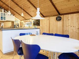 een eetkamer met een witte tafel en blauwe stoelen bij 6 person holiday home in Stubbek bing in Stubbekøbing