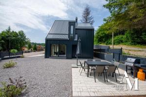 a small black house with a table and chairs at Gorska idila - Villa Jela in Stari Laz