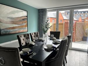 a dining room with a black table and chairs at Waterside House in Leicester