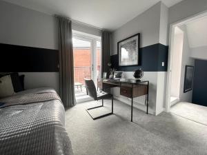 a bedroom with a desk and a bed and a window at Waterside House in Leicester