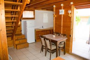 a kitchen with a table and chairs in a room at Arc de Bará Camping & Bungalows in Roda de Bará