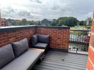 einen Balkon mit Sofa und Ziegelwand in der Unterkunft Waterside House in Leicester
