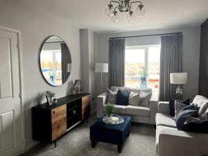 a living room with a couch and a mirror at Waterside House in Leicester