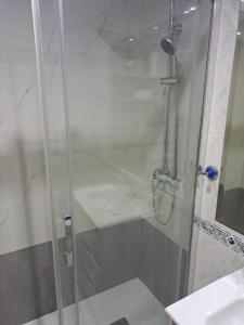 una ducha con una puerta de cristal junto a un lavabo en Isabel, en Valencia