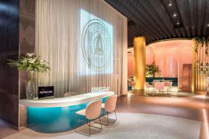 a lobby with a round table and chairs at Barceló Malaga in Málaga