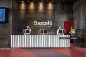 two people standing at a barberico at Barceló Malaga in Málaga