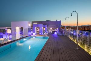 a pool on the roof of a building at night at Barceló Malaga in Málaga